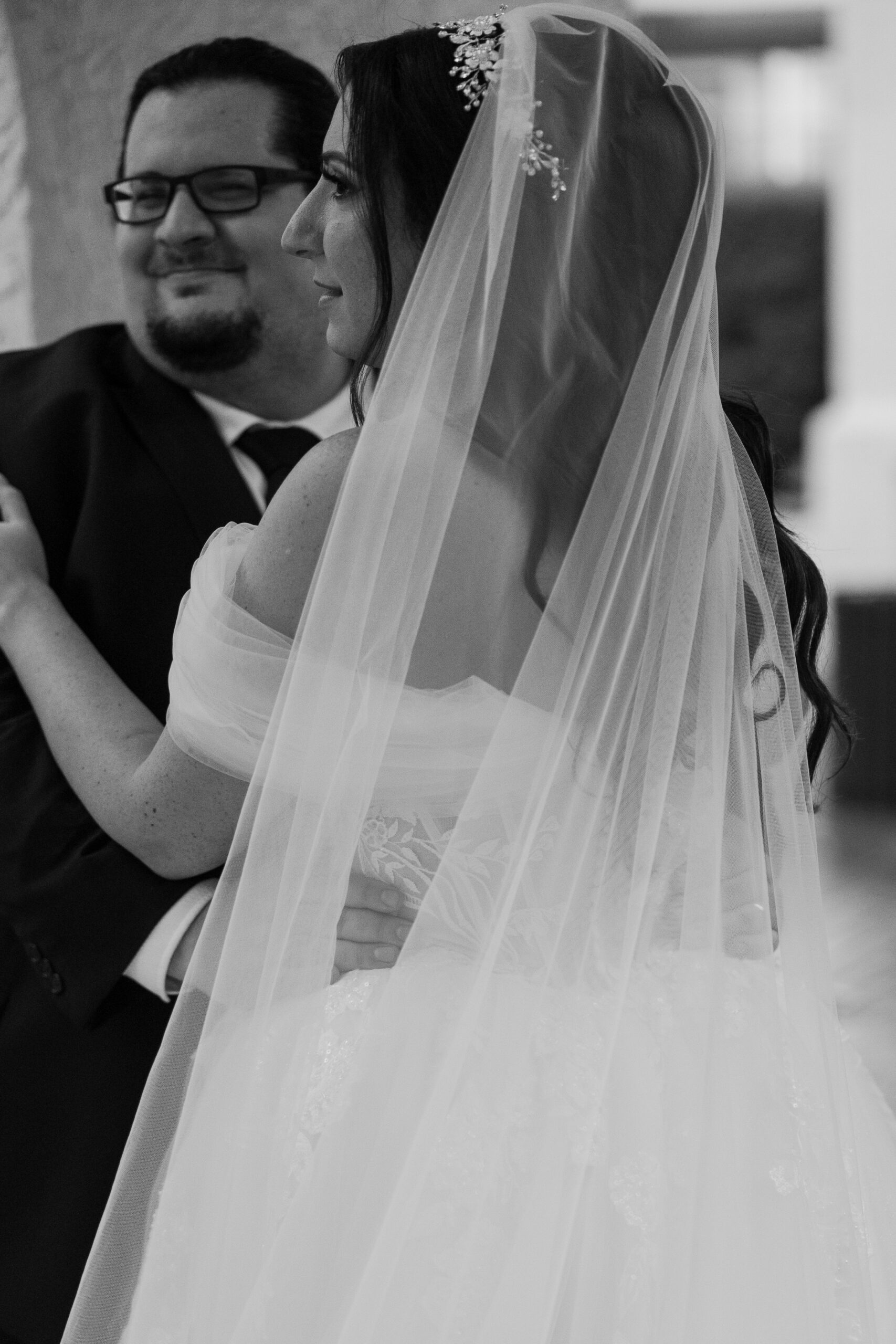 Bride and groom sharing a quiet moment during their wedding ceremony, captured in timeless black and white.